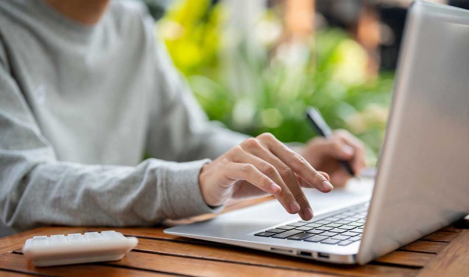 Foto: Frau schaut auf Laptop - 